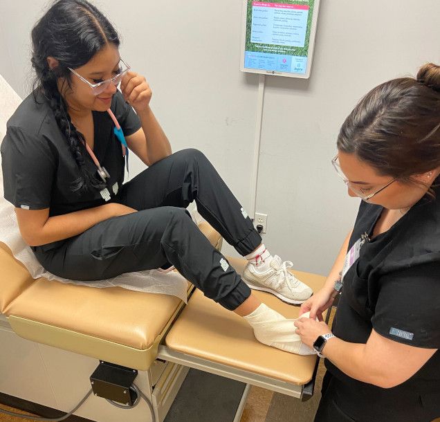 Medical students in lab practicing vitals in patient room